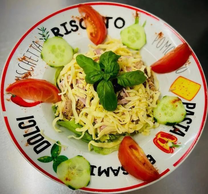 Pasta mit Schinken in Sahnesoße, garniert mit Basilikum